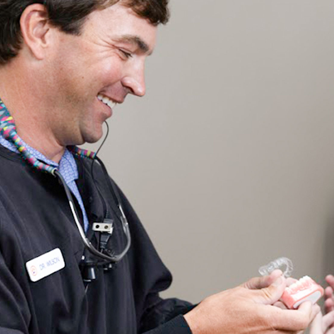 Image of Dr. Ron Wilson holding Invisalign aligners in Gainesville, GA | Wilson Orthodontics